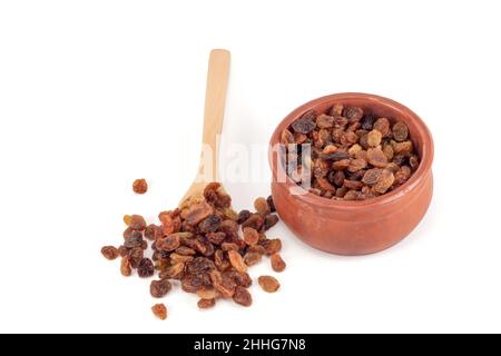 Raisins secs dans une cuillère à café.Raisins secs dans un bol isolé sur fond blanc. Banque D'Images