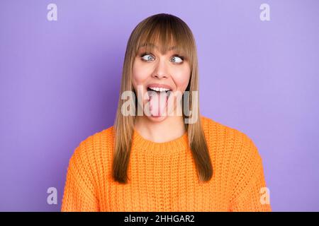 Photo portrait de fille blonde silly childish grimace montrant la langue isolée couleur pastel violet fond Banque D'Images