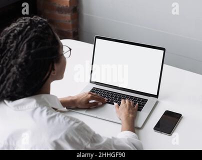 Jeune femme utilisant un ordinateur portable à la maison.Cache une maquette de moniteur d'écran vide.Étudiant fille d'apprentissage en ligne. Banque D'Images