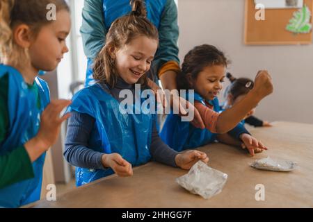 Groupe de petits enfants travaillant avec de l'argile poterie pendant la création artistique et cours d'artisanat à l'école. Banque D'Images