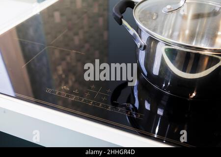 Gros plan de pots en acier inoxydable sur une cuisinière à induction dans une cuisine moderne. Le concept d'une cuisine moderne. Banque D'Images