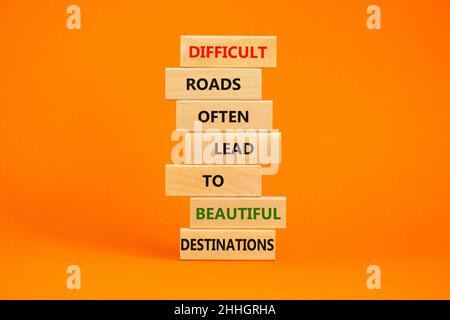 Symbole de motivation.Des blocs avec des mots routes difficiles mènent souvent à de belles destinations.Belle table orange, fond orange, espace de copie.Unité commerciale Banque D'Images