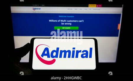 Personne tenant un smartphone avec le logo de la compagnie d'assurance britannique EUI Limited (Admiral) à l'écran devant le site Web.Mise au point sur l'affichage du téléphone. Banque D'Images