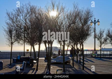 La promenade sur le front de mer de Worthing pendant une journée d'hiver ensoleillée avec un soleil bas débordant d'arbres créant de fortes ombres West Sussex Angleterre Royaume-Uni Banque D'Images