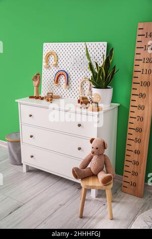 Intérieur d'une élégante chambre pour enfants avec commode, stadiomètre et panneau perforé Banque D'Images