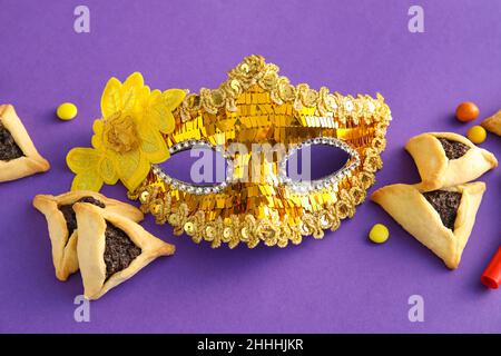 Masque de carnaval et biscuits Hamantaschen pour les vacances de Purim sur fond de couleur Banque D'Images