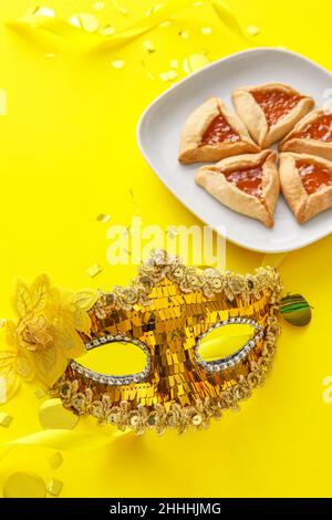 Masque de carnaval et biscuits Hamantaschen pour les vacances de Purim sur fond de couleur Banque D'Images