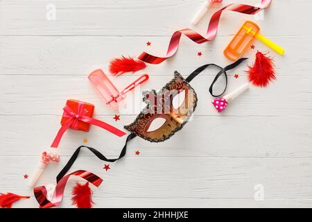 Masque de carnaval et hochets pour les vacances de Purim avec décor de fête sur fond de bois blanc Banque D'Images