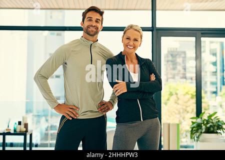 Sympa centre de remise en forme.Portrait de deux physiothérapeutes heureux se posant ensemble dans un centre de fitness. Banque D'Images