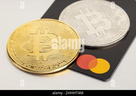 Galice, Espagne; 24 janvier 2022: Bitcoin crypto-monnaie et carte Mastercard sur table grise Banque D'Images