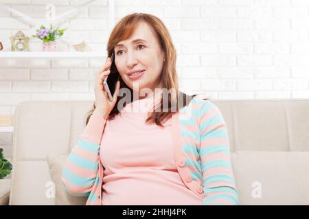 Femme talkin sur téléphone portable.Femme d'âge moyen.Copier l'espace et la maquette.Lieu de travail Banque D'Images