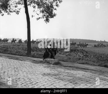 L'artillerie belge vue ici prendre position dans un champ proche de Termonde, où leur feu a causé la retraite des Allemands dans un certain désordre.Un soldat blessé est vu assisté le long de la route par un camarade.Septembre 1914 Banque D'Images