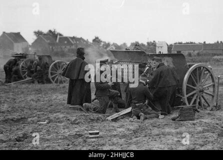 Un canon de campagne belge en action pendant la bataille de Hofstade.Alimenter un canon avec des coquilles.Les hommes vont tranquillement et méthodiquement au sujet de leur travail, et il sera remarqué qu'ils fument leurs tuyaux comme si prenant part à des manoeuvres.Au cours du séjour de Tom Grant près de l'arme à feu, quatre hommes ont été transportés grièvement blessés par un shrapnel. Banque D'Images