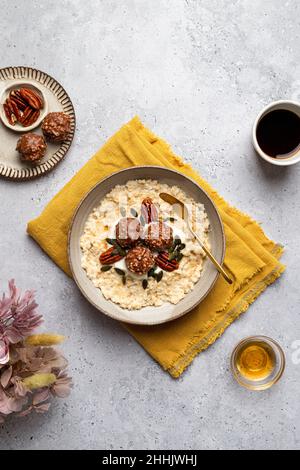 Bol à grand angle avec savoureux flocons d'avoine au lait servi avec des boulettes de chocolat croquantes de graines de citrouille et de noix de pécan sur la serviette pour un petit déjeuner sain Banque D'Images