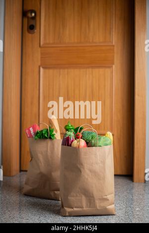 Des sacs de shopping de nourriture sont à la porte de la maison ou de l'appartement.Livraison de légumes et de fruits pendant la quarantaine et l'auto-isolement Banque D'Images