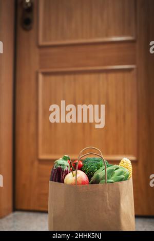 Des sacs de shopping de nourriture sont à la porte de la maison ou de l'appartement.Livraison de légumes et de fruits pendant la quarantaine et l'auto-isolement Banque D'Images