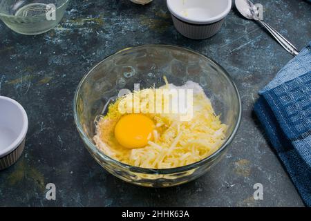 De dessus de bol en verre avec oeuf brut et beurre râpé pour les chaffles sucrées avec le fromage placé sur la table dans la cuisine légère Banque D'Images