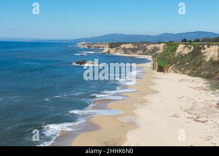Vue aérienne de la plage de sable vide, des affleurements rocheux, des falaises de grès, des promontoires rocheux et de l'océan Pacifique le jour d'hiver ensoleillé près de Half Moon Bay à Califo Banque D'Images