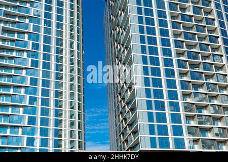 Façade en verre de deux bâtiments résidentiels modernes.Ciel bleu entre les bâtiments Banque D'Images