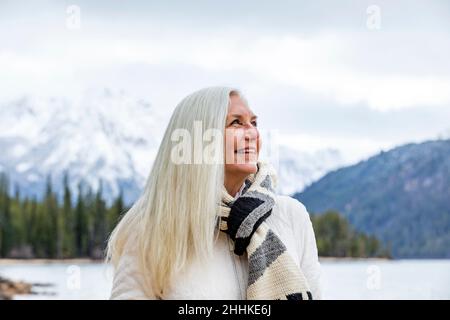 USA, Idaho, Stanley, femme âgée souriante au lac de montagne Banque D'Images