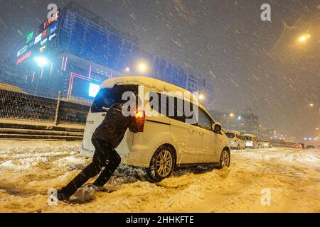 Un homme a vu pousser une voiture sur une route enneigée.La tempête de neige qui a commencé à Istanbul dans la soirée a paralysé la vie malgré les mesures prises.Alors que les services du Metrobus ont été interrompus pendant une courte période, l'autoroute D-100 de l'emplacement de Haramidere a été fermée à la circulation en raison de la forte chute de neige.De nombreux véhicules sont restés sur la route pendant des heures.Les citoyens se sont mobilisés pour sauver les véhicules.Le bureau du gouverneur d'Istanbul a averti les conducteurs qu'ils ne seraient pas en mesure d'entrer dans la ville depuis Thrace, une région qui s'étend de l'autre côté de la partie européenne de la Turquie à sa frontière occidentale avec la Bulgarie et la Grèce.(Pho Banque D'Images