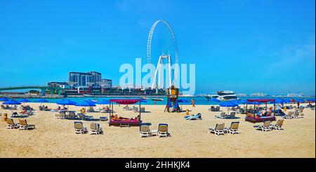 Panorama de la plage JBR Marina avec chaises longues, parasols et vue sur l'île Bluewaters et la grande roue Ain Dubai Ferris Wheel, Dubaï, Émirats Arabes Unis Banque D'Images