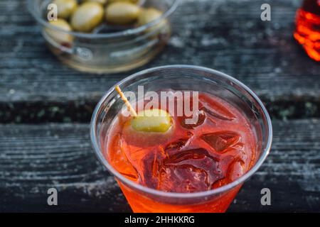 Aperol spritz dans une tasse en plastique avec olives vertes à l'extérieur Banque D'Images