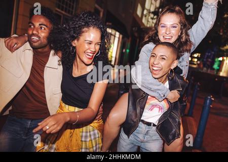 Les jeunes rient et vivent leur meilleure vie dans la ville.Les jeunes heureux s'amusent tout en se traînant ensemble la nuit.Des amis éclatants Banque D'Images