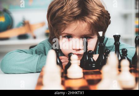 Petit garçon jouant aux échecs.Jeux éducatifs pour enfants, développement précoce pour les enfants.Garçon pense ou plan au jeu d'échecs, style vintage pour le concept d'éducation. Banque D'Images