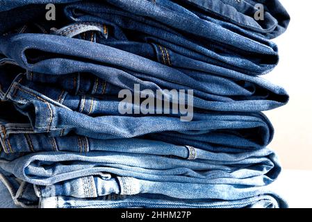 une pile de jeans bleus sur fond blanc.Lumière du soleil.Gros plan Banque D'Images