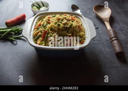 Repas indien maison pulao ou riz frit aux légumes ou biryani servi dans un bol.Gros plan. Banque D'Images