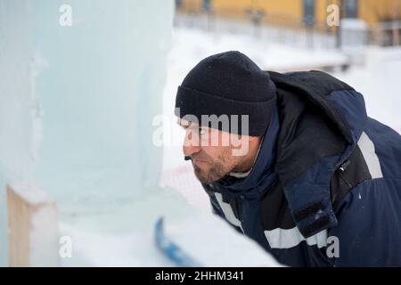 Gros plan du visage d'un travailleur dans une veste bleue sur le lieu de travail Banque D'Images