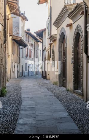 Paysage urbain avec des bâtiments historiques sur une étroite ruelle pavée, photographiée sous la lumière d'hiver à Rovato, Brescia, Italie Banque D'Images