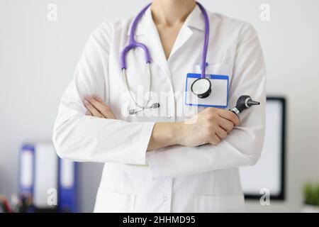 Un otolaryngologiste dans un manteau blanc tient un otoscope Banque D'Images