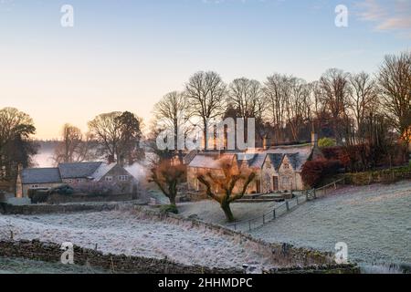 Cotswold cottages en pierre dans le gel d'hiver au lever du soleil.Hampnet, Cotswolds, Gloucestershire, Angleterre Banque D'Images