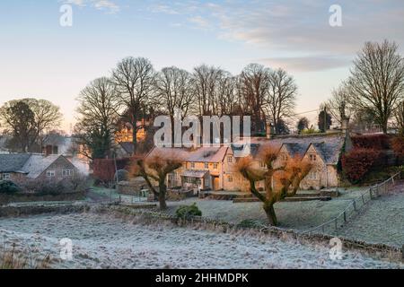 Cotswold cottages en pierre dans le gel d'hiver au lever du soleil.Hampnet, Cotswolds, Gloucestershire, Angleterre Banque D'Images