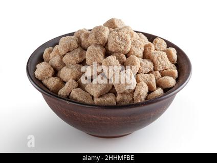 Cubes de sucre de canne à sourcils dans un bol en céramique isolé sur fond blanc avec passe-cheveux Banque D'Images