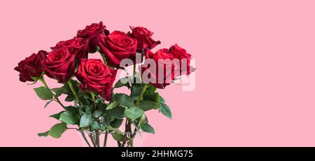 Bouquet de roses romantiques rouges sur fond rose. Banque D'Images