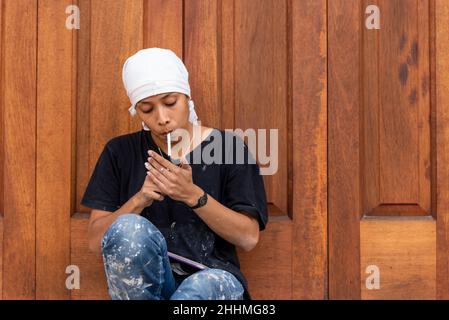 Femme travailleuse de la construction en pause fume une cigarette. Banque D'Images