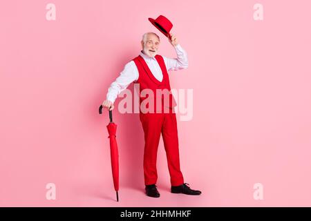 Pleine photo de l'homme âgé heureux positif sourire salutations tenir chapeau parasol temps isolé sur fond rose couleur Banque D'Images