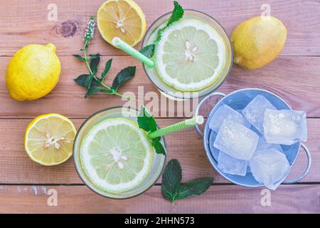 Vue de dessus d'une table désordonnée avec des ingrédients et des verres de limonade fraîche Banque D'Images