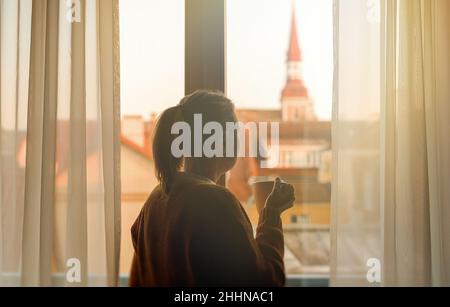 Femme avec mug appréciant ses vacances dans la vieille ville. Banque D'Images