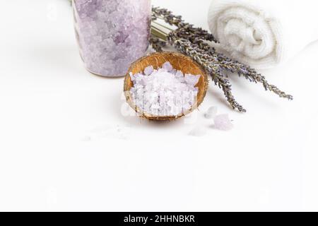 Sel de bain de lavande dans un bol de noix de coco avec bouquet de fleurs de lavande sèches et serviette blanche Banque D'Images