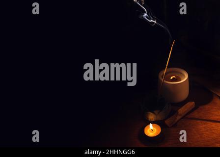 Bâtons d'arôme d'Encens couvant sur la table porte-lotus et bougie dans l'obscurité.Zen, méditation, santé mentale zone de confort Banque D'Images