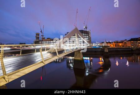 Photo nocturne du pont Tradeston (Squiggly) au-dessus de la rivière Clyde, le soir d'hiver calme. Banque D'Images