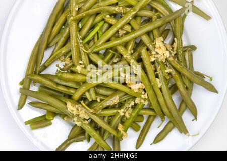 Taille de portion de haricots verts cuits avec sauce à l'ail Banque D'Images