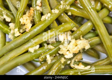 Macro de haricots verts cuits avec sauce à l'ail sur le dessus Banque D'Images