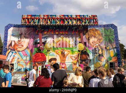 Été au Royaume-Uni ; les personnes avec enfants et la famille apprécient les manèges du parc des expositions dans une foire amusante en été, Hertfordshire au Royaume-Uni Banque D'Images