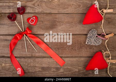 Arrière-plan de la Saint-Valentin avec coeurs de jouets faits main et anneau sur table en bois Banque D'Images