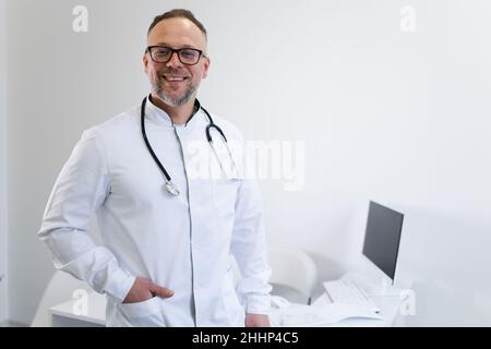 Souriant médecin masculin avec stéthoscope autour de son cou regardant la caméra Banque D'Images